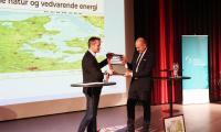 Kristian Jensen overrækker kugleramme til miljøminister Magnus Heunicke (S) på konferencen Grøn energi og natur: hvordan giver vi plads til begge? 25. januar 2024
